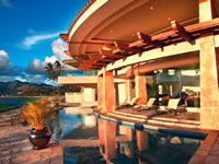 Swimming pool borders lanai and follows curve of roof overhang